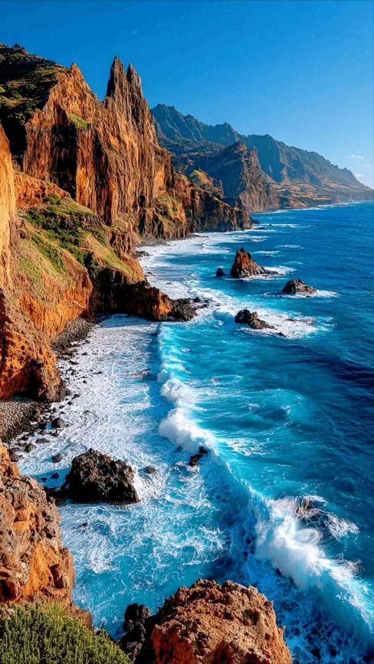 This may contain: an ocean view with waves crashing on the rocks and cliffs in the foreground,