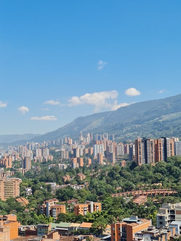 This may contain: the city is surrounded by mountains and trees