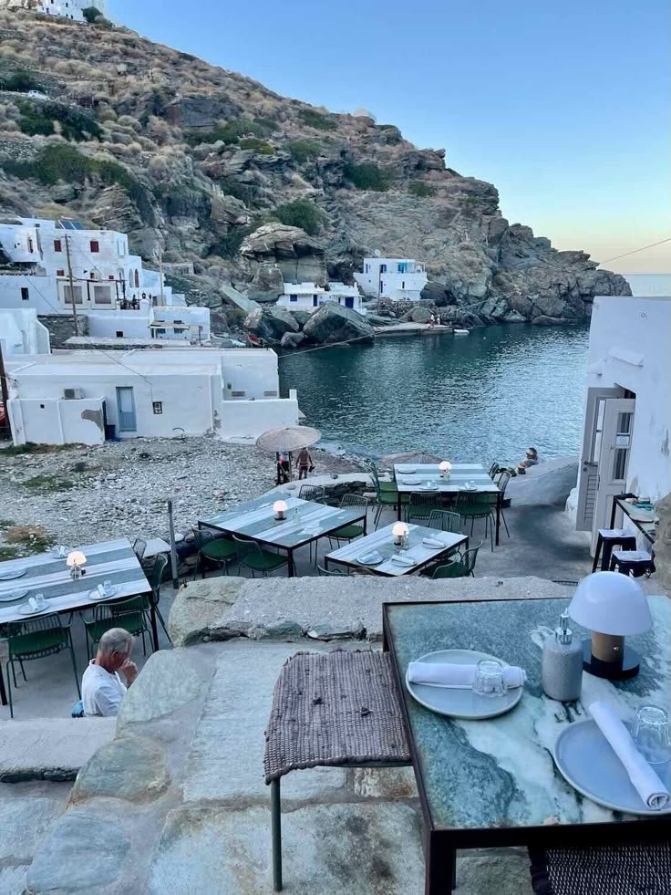 This may contain: an outdoor dining area next to the ocean