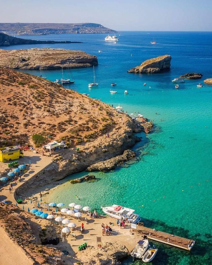 This may contain: an aerial view of boats docked at the beach