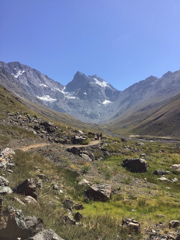 This may contain: a person walking on a trail in the mountains