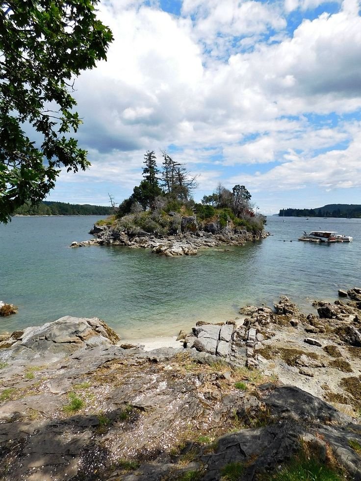 This may contain: an island in the middle of water surrounded by rocks