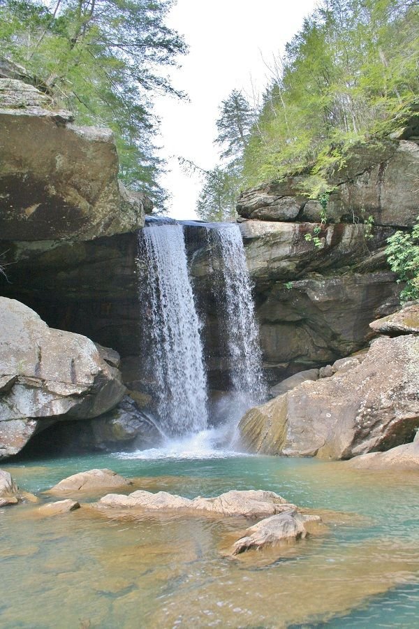 This may contain: there is a waterfall in the middle of some rocks