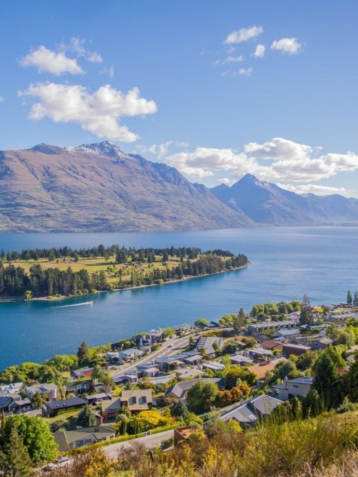 This may contain: an aerial view of the town of queenstown and lake wakatu in new zealand