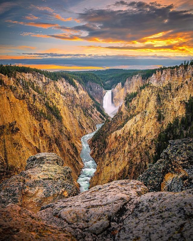 This may contain: the grand canyon is shown at sunset with a river running through it and mountains in the background