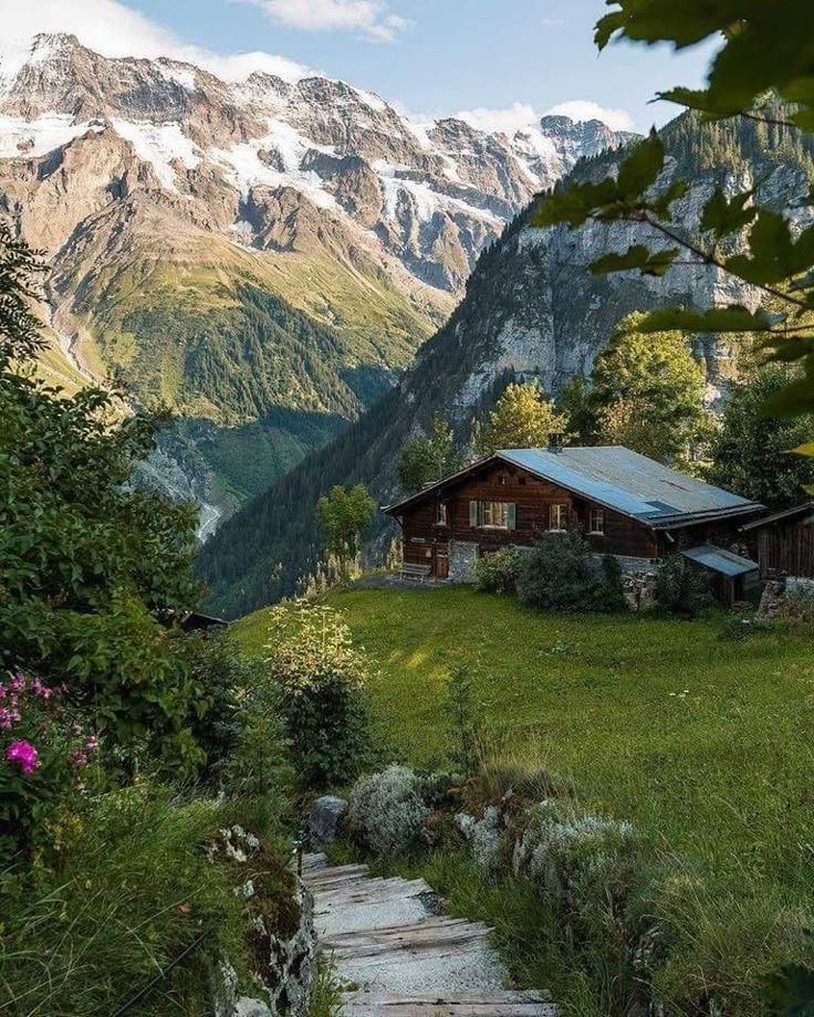 This may contain: a house in the mountains with stairs leading up to it