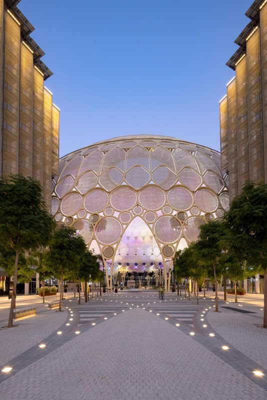 This may contain: a large circular building with trees in front of it