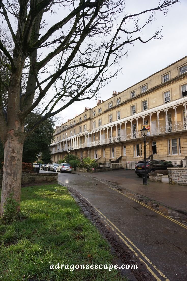 This may contain: an old building with many windows and balconies on the front, next to a tree