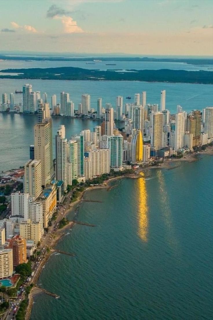 This may contain: an aerial view of a large city next to the ocean with tall buildings on both sides