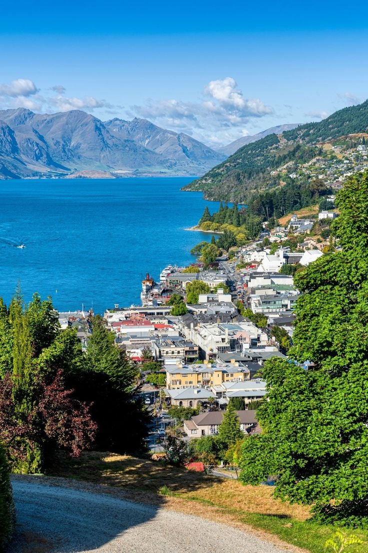 This may contain: a scenic view of the town of queenstown and lake wakatu in new zealand