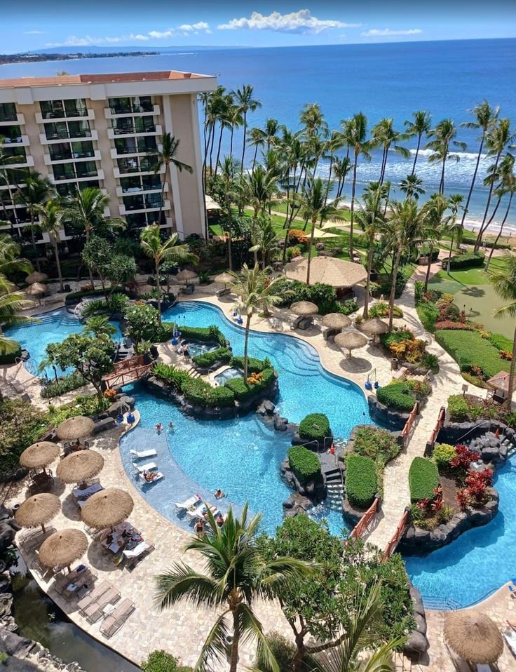 This may contain: an aerial view of a resort pool and beach