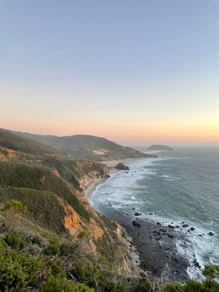 This may contain: the coast line at sunset with waves crashing on it