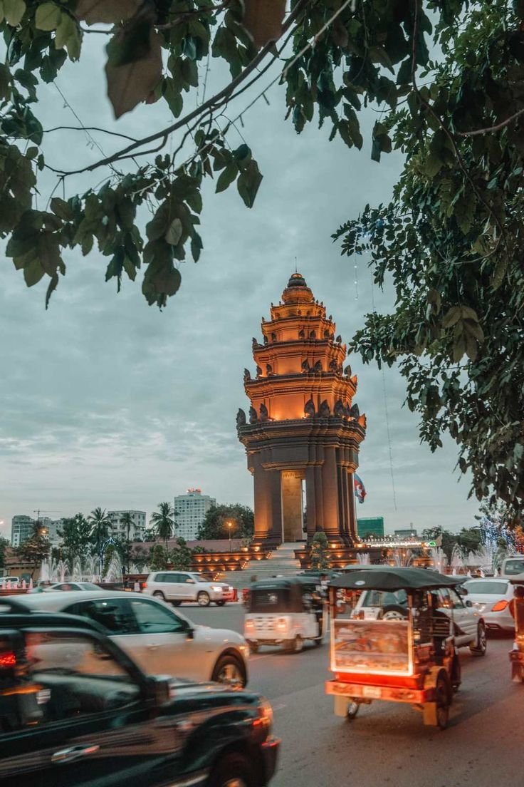 This may contain: cars driving down the road in front of a pagoda