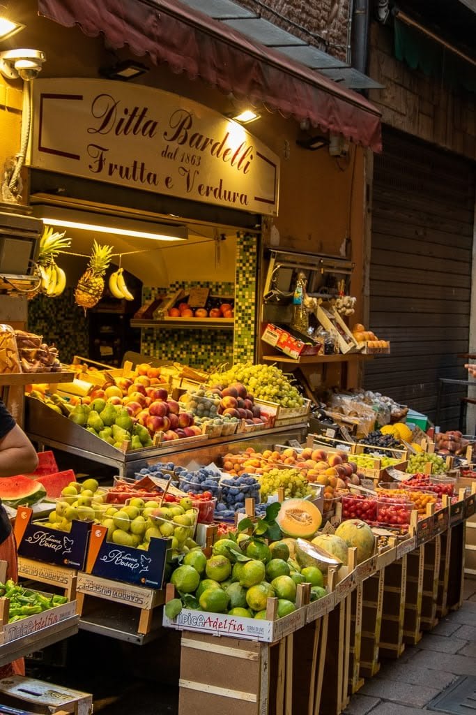 This may contain: a fruit stand with lots of fresh fruits and vegetables on display in front of it