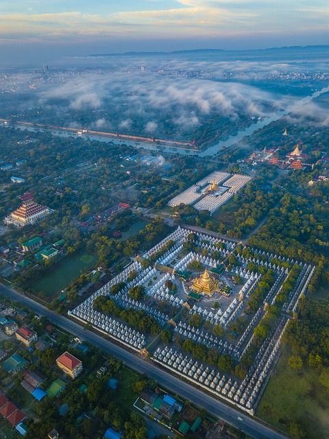 This may contain: an aerial view of a city surrounded by clouds