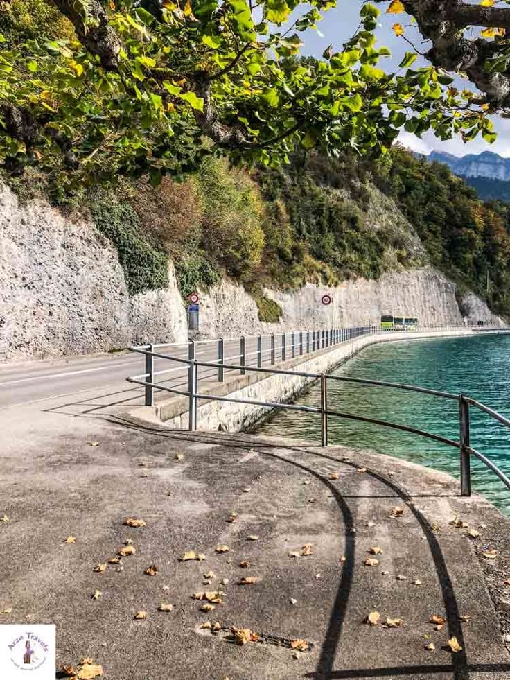 This may contain: an empty road next to the water