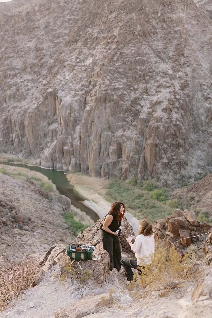 This contains: A man proposes to his girlfriend on an overlook in West Texas