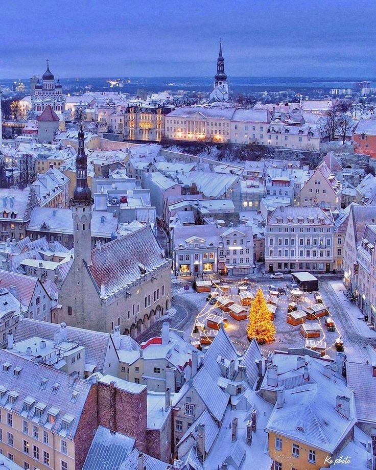 This may contain: the city is covered in snow and lit up with christmas lights at night, as seen from above