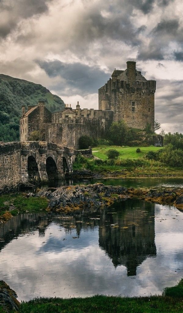 This may contain: an old castle is reflected in the water