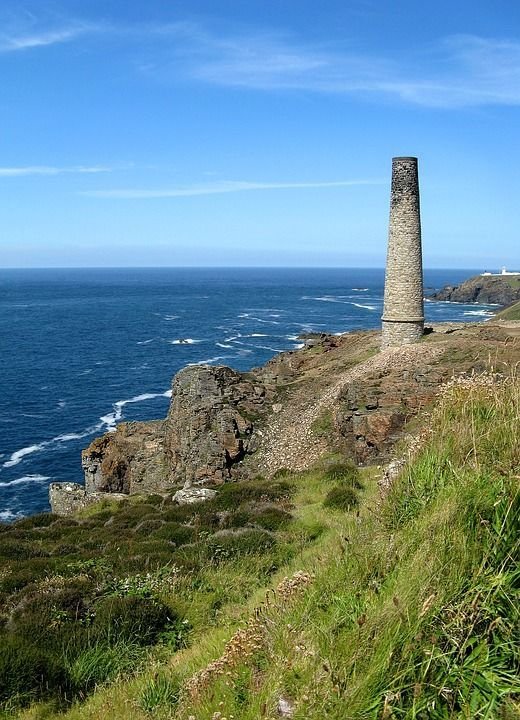 This may contain: a stone tower on top of a cliff near the ocean