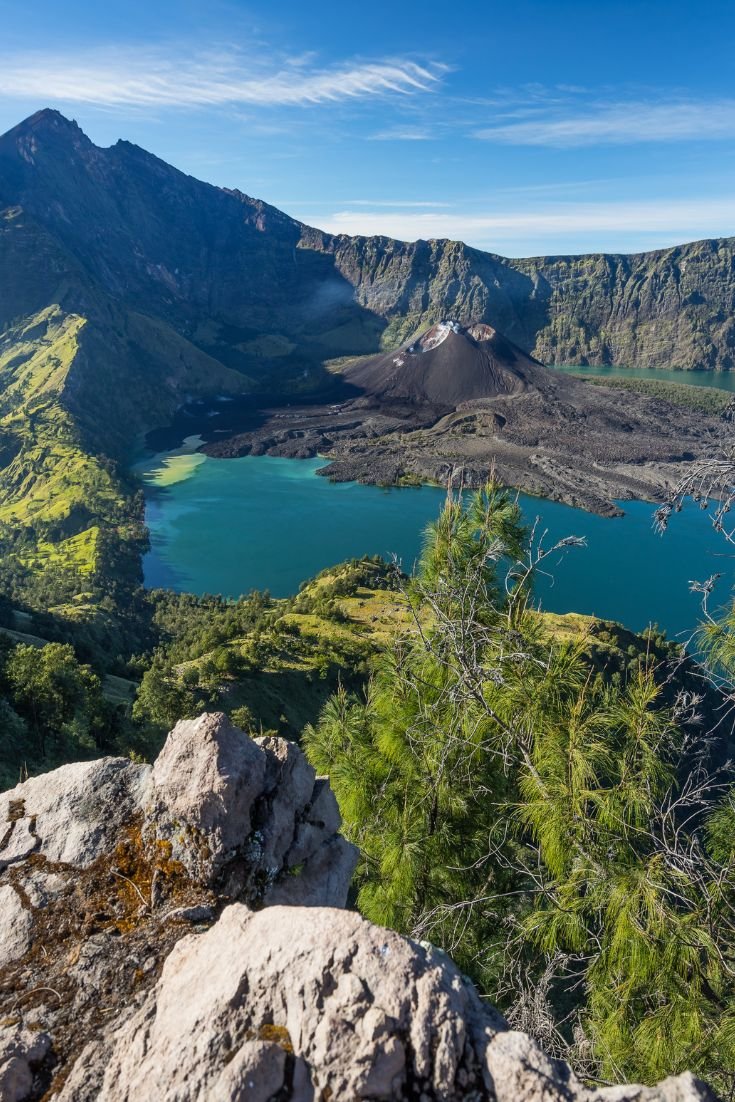 This may contain: the view from top of a mountain looking down on a lake and mountains