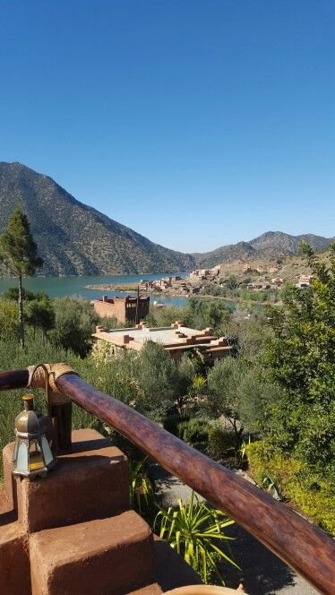 This may contain: stairs lead up to the top of a hill overlooking a lake and mountains in the distance