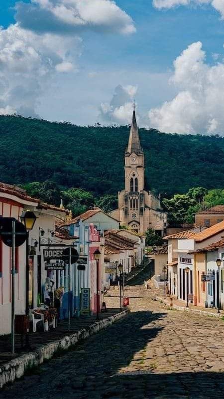 This may contain: a cobblestone street with buildings and a church in the background