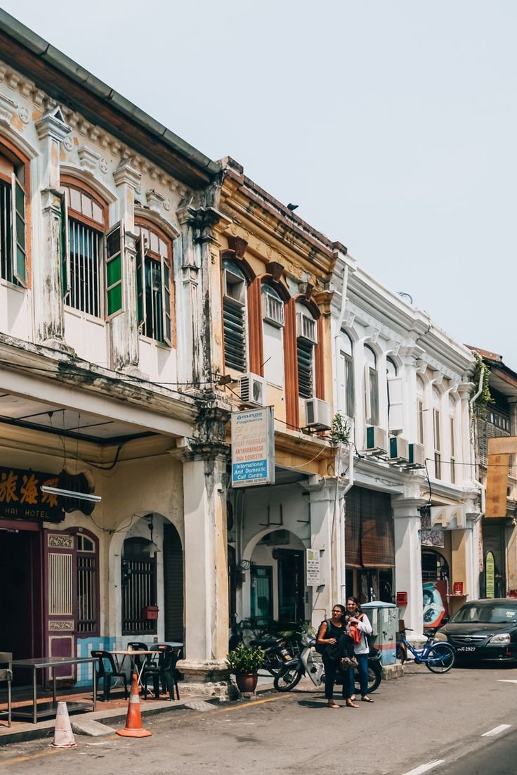 This may contain: people are walking down the street in front of old buildings
