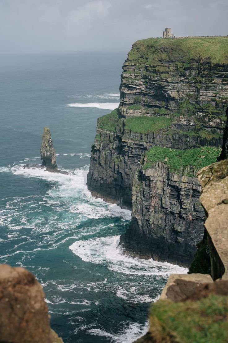 This may contain: the cliffs are very high on the water