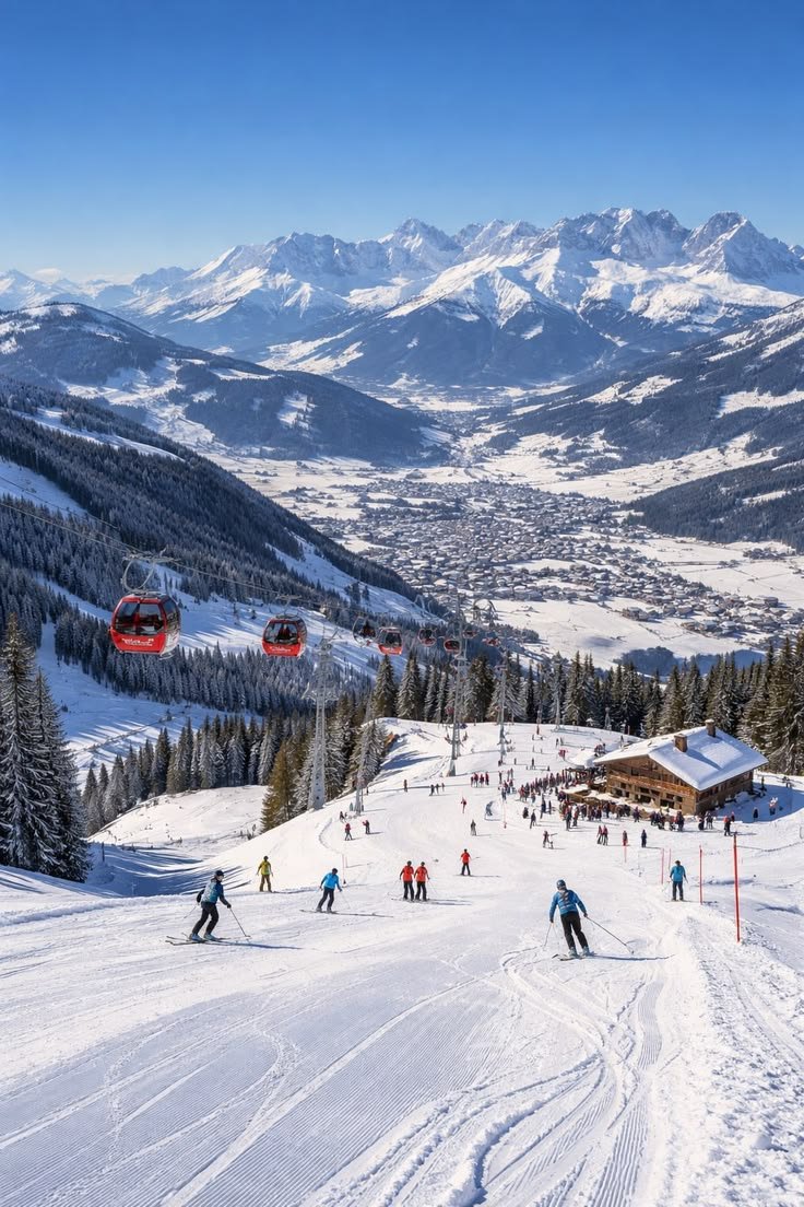This may contain: skiers and snowboarders skiing down a snowy slope with mountains in the background