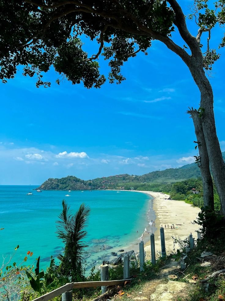 This may contain: the beach is surrounded by trees and blue water