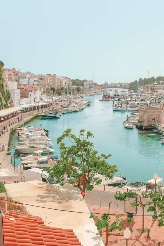 This may contain: a harbor filled with lots of boats on top of it's sides and surrounded by buildings