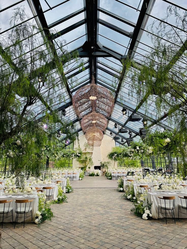 This may contain: the inside of a building with tables and chairs set up for an outdoor wedding reception