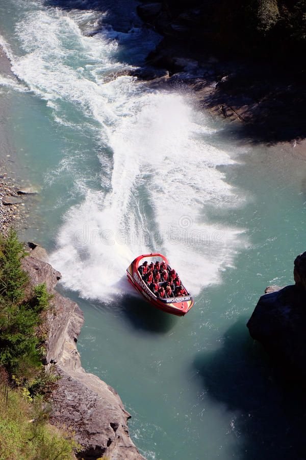 This may contain: a red boat with people in it is going down the river royalty images and stock photos