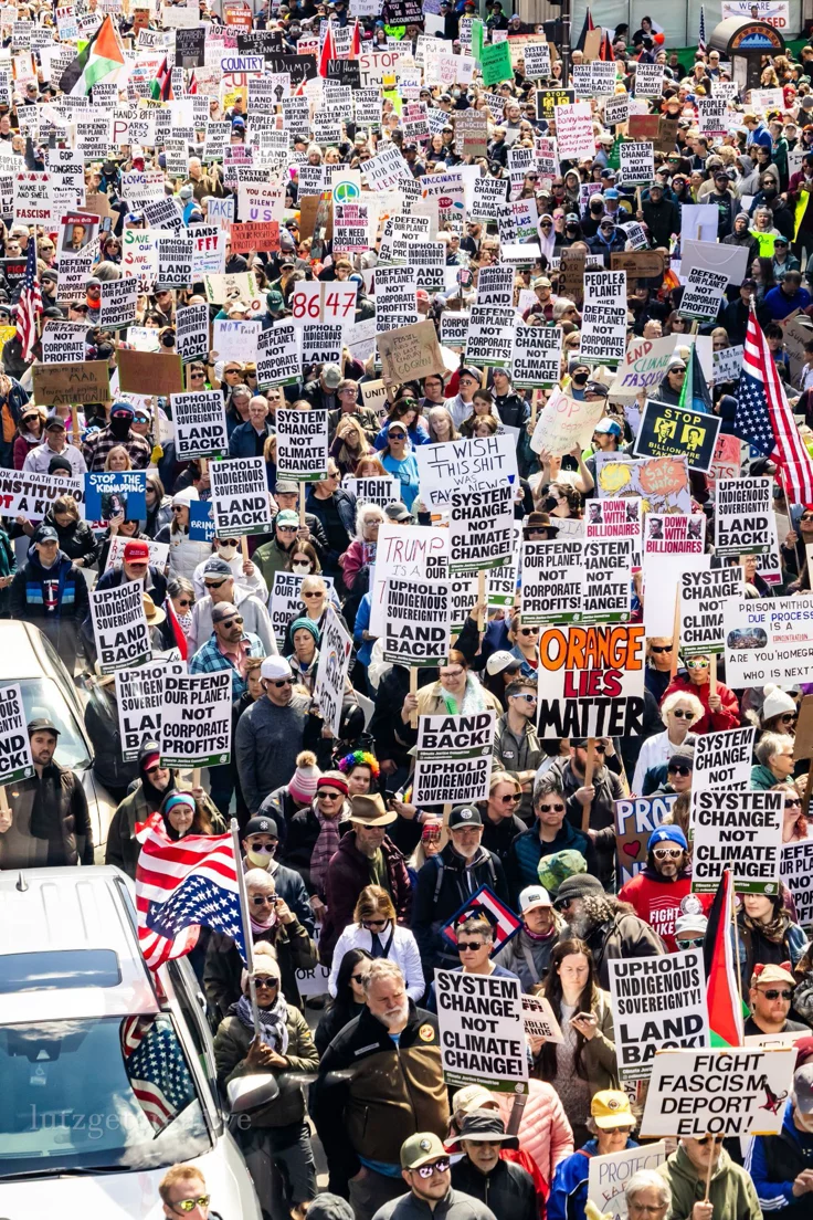This may contain: a large group of people holding signs and flags
