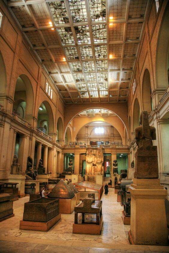 This may contain: the inside of an old building with statues and other items on display in front of them