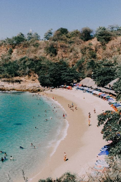 This may contain: an aerial view of a beach with people on the sand and umbrellas in the water