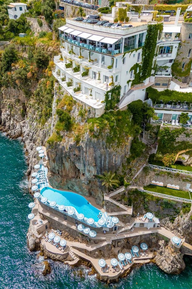This may contain: an aerial view of the ocean and hotels in caprifica on the amalfa peninsula, italy