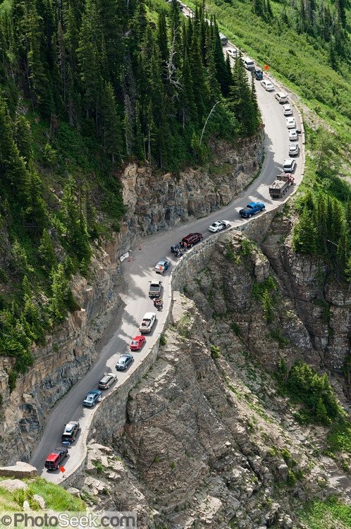 This may contain: cars are lined up on the side of a mountain road