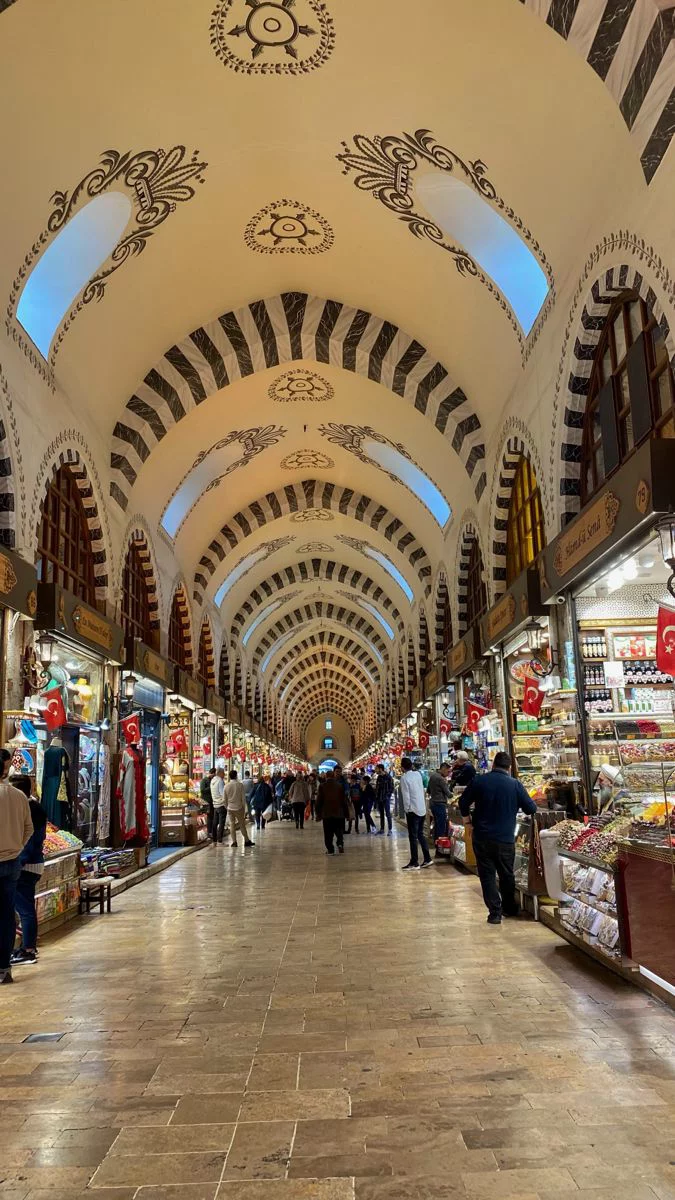 This may contain: people are walking through an ornately decorated shopping mall with high ceilings and arched arches