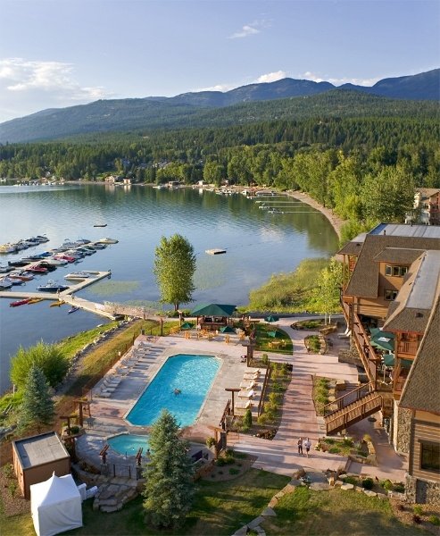 This may contain: an aerial view of a resort with a swimming pool and boat dock in the foreground