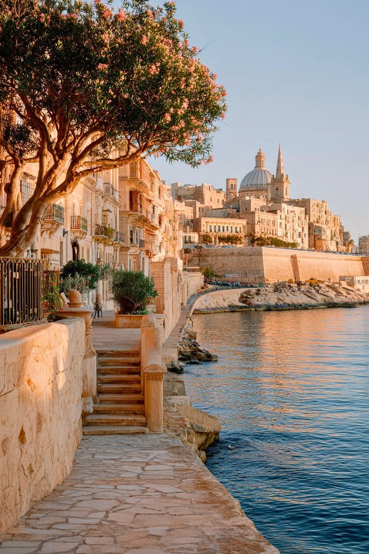This may contain: the water is calm and blue with buildings on both sides, along with steps leading up to it