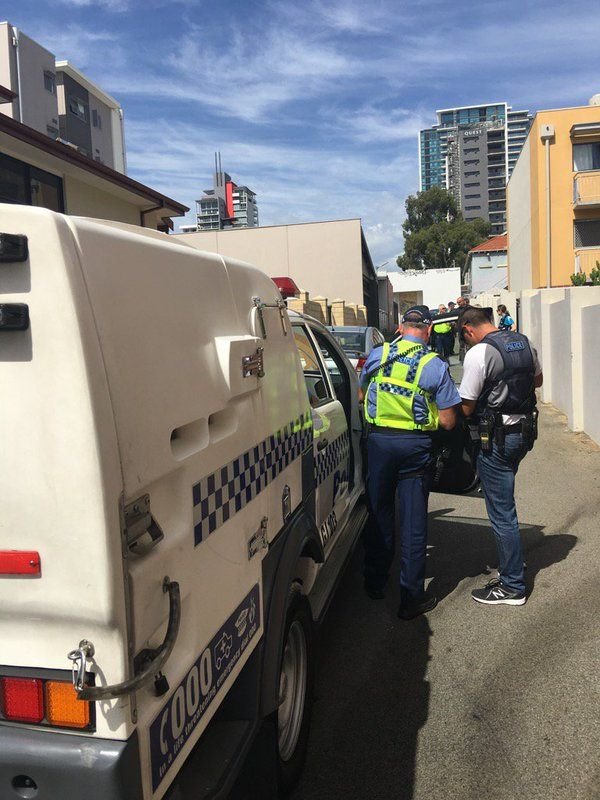 This may contain: two police officers standing next to a white van