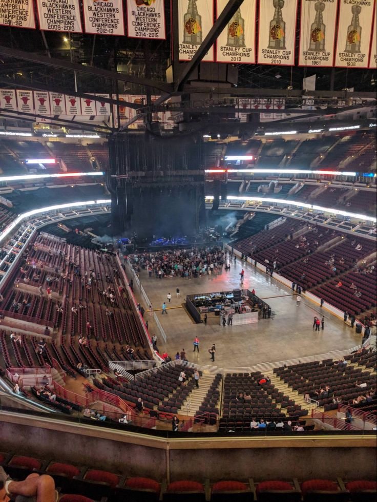 This may contain: the inside of an arena with people sitting in seats and standing on the sidelines