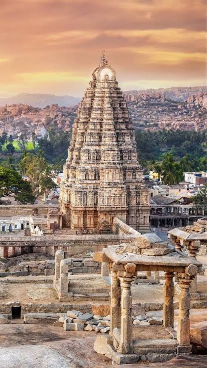 This may contain: an ancient temple in india with the sun setting over the city and hills behind it