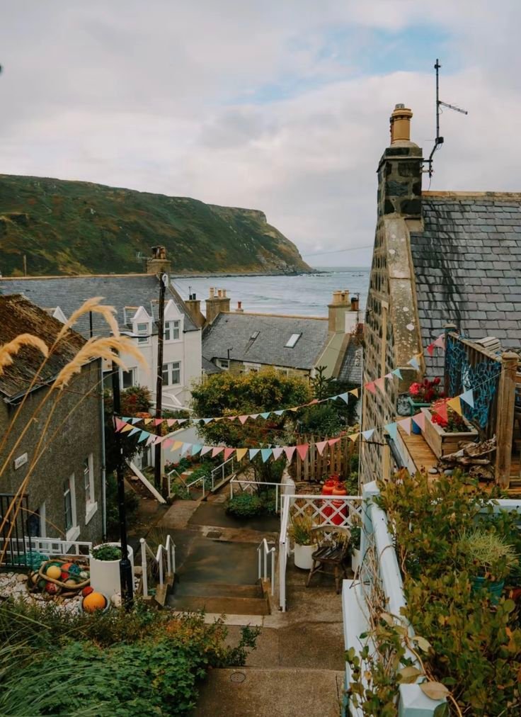 This may contain: an aerial view of houses on the coast with flags flying in the air above them