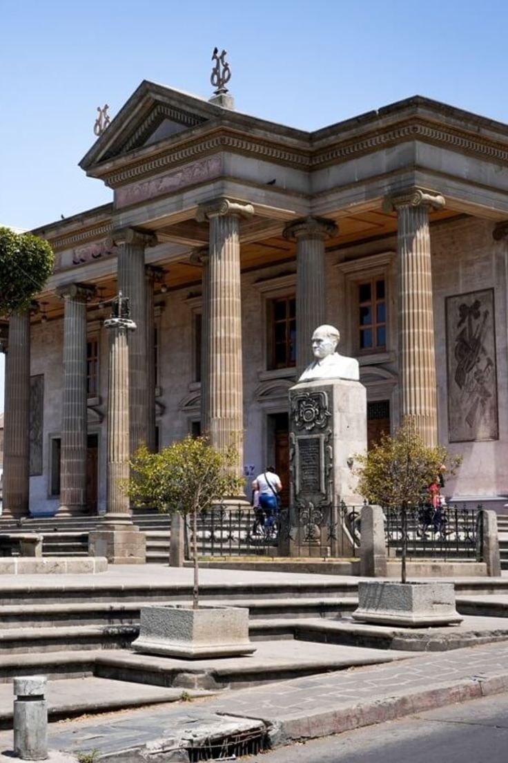 This may contain: an old building with columns and statues in front
