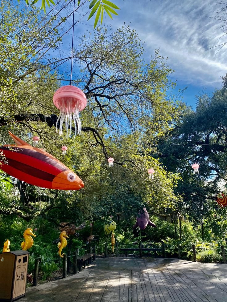 This may contain: an outdoor area with wooden floors and umbrellas hanging from the trees