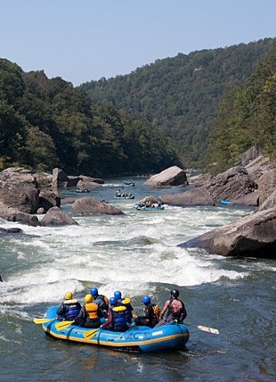 This may contain: people are rafting down a river with rocks in the background