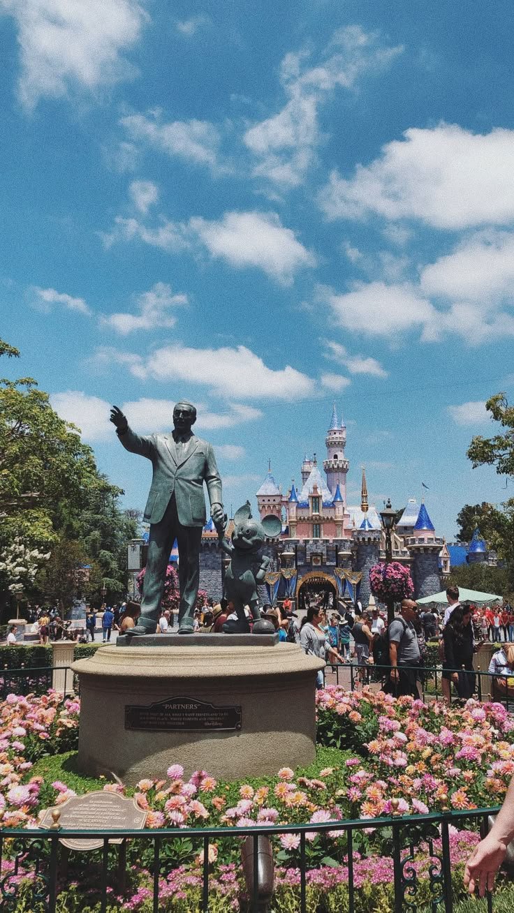 This may contain: there is a statue in the middle of a flower garden